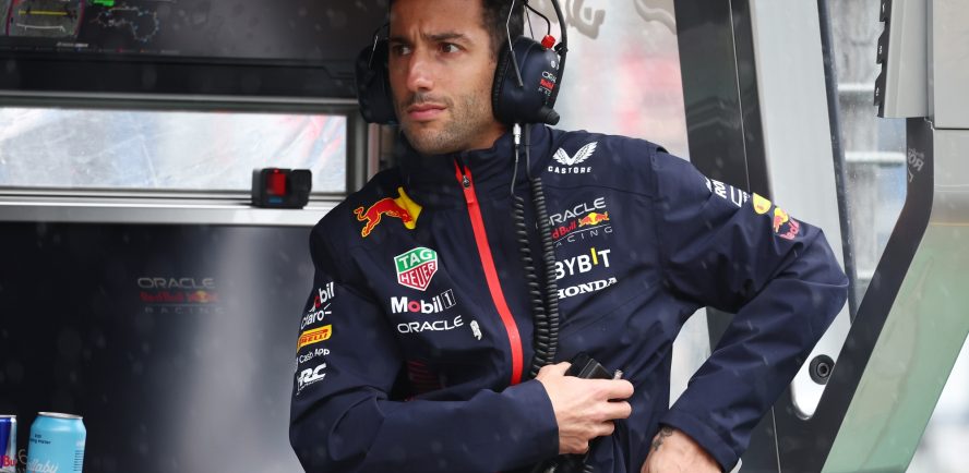 Red Bull Formula 1 reserve driver Daniel Ricciardo sitting at the pit wall in the Formula 1 paddock