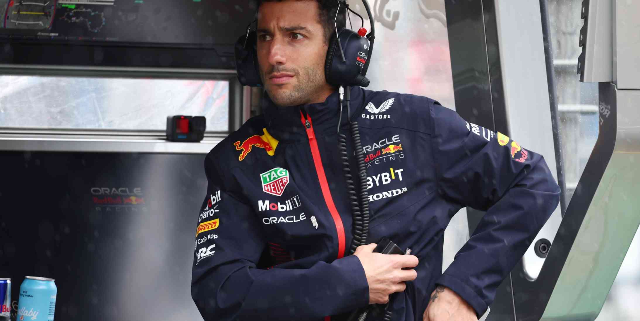 Red Bull Formula 1 reserve driver Daniel Ricciardo sitting at the pit wall in the Formula 1 paddock